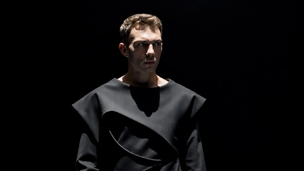 Observer I — Gabriel Wyatt in a black sculptural look, gazing toward center.